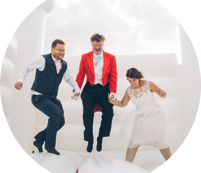 Toastmaster with bride and groom on a bouncy castle